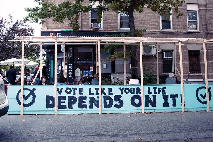 A photo of outdoor dining setup with message, "Vote like your life depends on it"